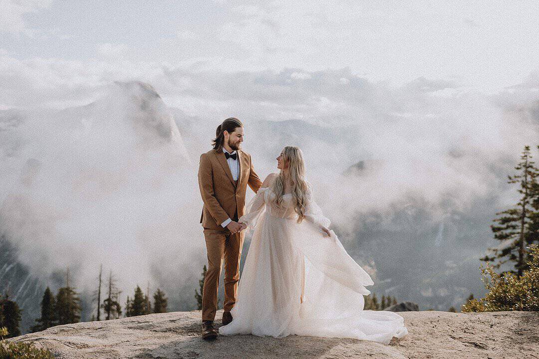 Bride and groom portraits at Yosemite National Park. The groom is wearing a camel brown suit, and the bride has a flowing dress and earth toned flowers | Yosemite Elopement in the Clouds | Summit and Sur | Zion Brides Feature