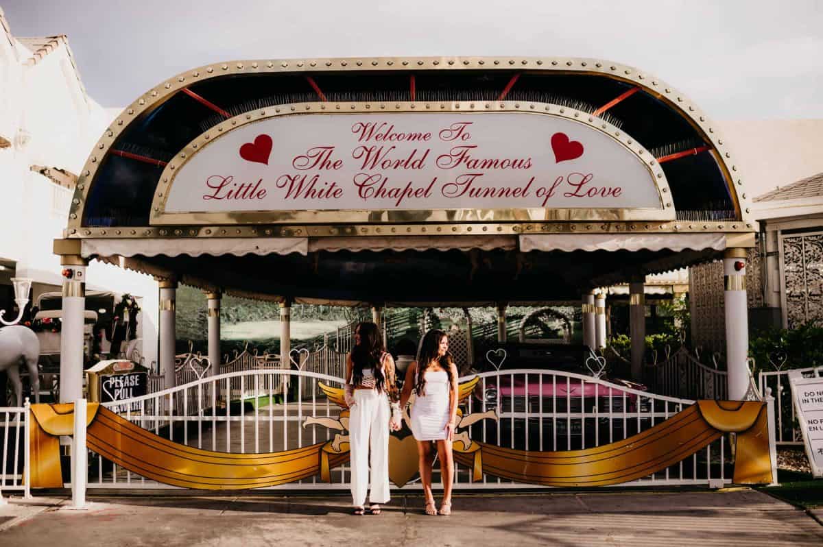 Brides taking photos together outside of the Little White Chapel | Las Vegas Getaway Elopement at the Little White Chapel | Amber Garrett Photography | Adventure Wed Feature