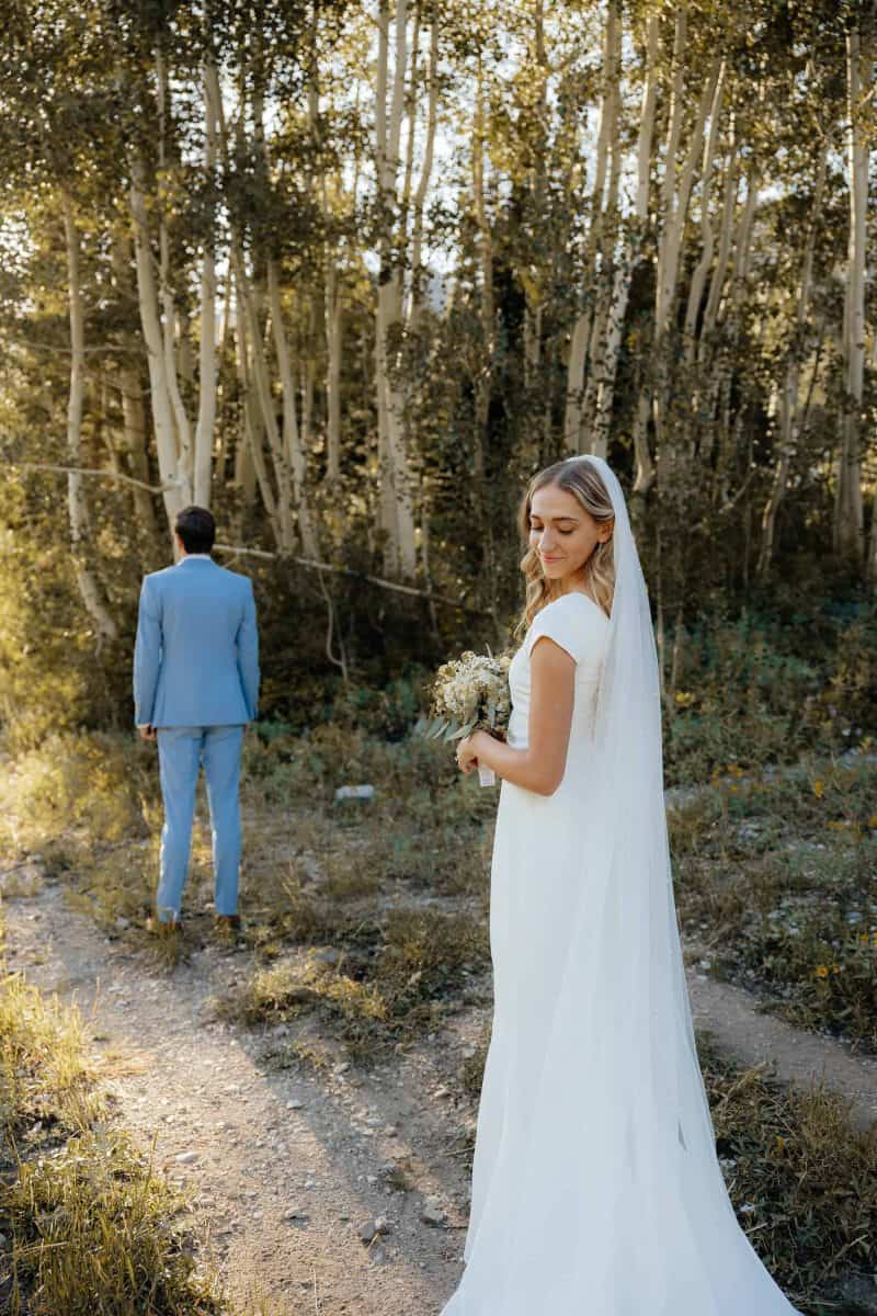 Alta Utah Summer Wedding Formal Session Groom in powder blue suit with blue floral tie, bride in classic white dress and veil with white floral wildflower bouquet | Alta Utah Summer Wedding Formal Session | Kae D Photography | Adventure Wed Feature