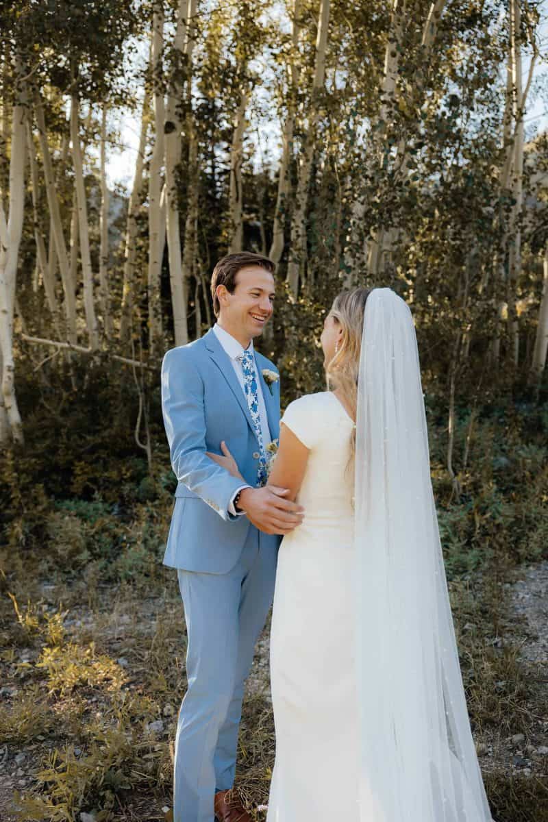 Alta Utah Summer Wedding Formal Session Groom in powder blue suit with blue floral tie, bride in classic white dress and veil with white floral wildflower bouquet | Alta Utah Summer Wedding Formal Session | Kae D Photography | Adventure Wed Feature