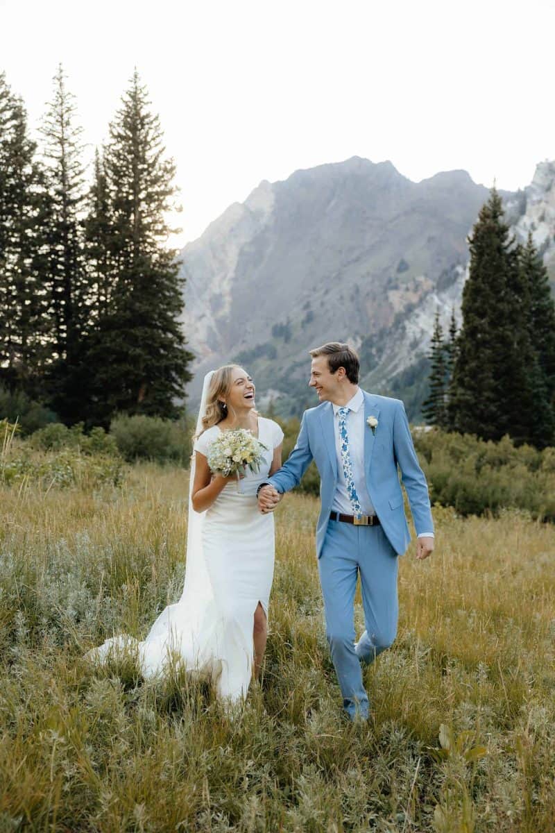 Alta Utah Summer Wedding Formal Session Groom in powder blue suit with blue floral tie, bride in classic white dress and veil with white floral wildflower bouquet | Alta Utah Summer Wedding Formal Session | Kae D Photography | Adventure Wed Feature