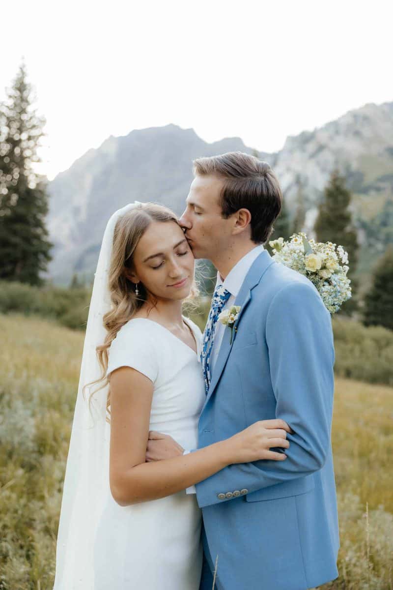 Alta Utah Summer Wedding Formal Session Groom in powder blue suit with blue floral tie, bride in classic white dress and veil with white floral wildflower bouquet | Alta Utah Summer Wedding Formal Session | Kae D Photography | Adventure Wed Feature