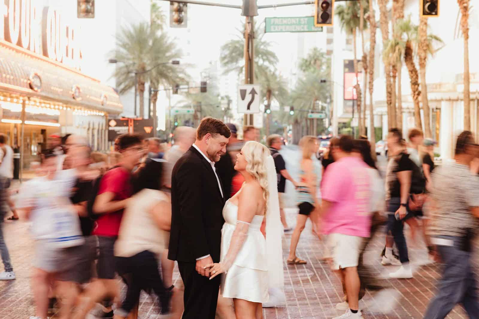 Bride and groom share a moment surrounded by people in Las Vegas | Ceremony inside the Little White Chapel | Downtown Las Vegas Elopement at The Little White Chapel | Amber Garrett Photography | Adventure Wed Feature