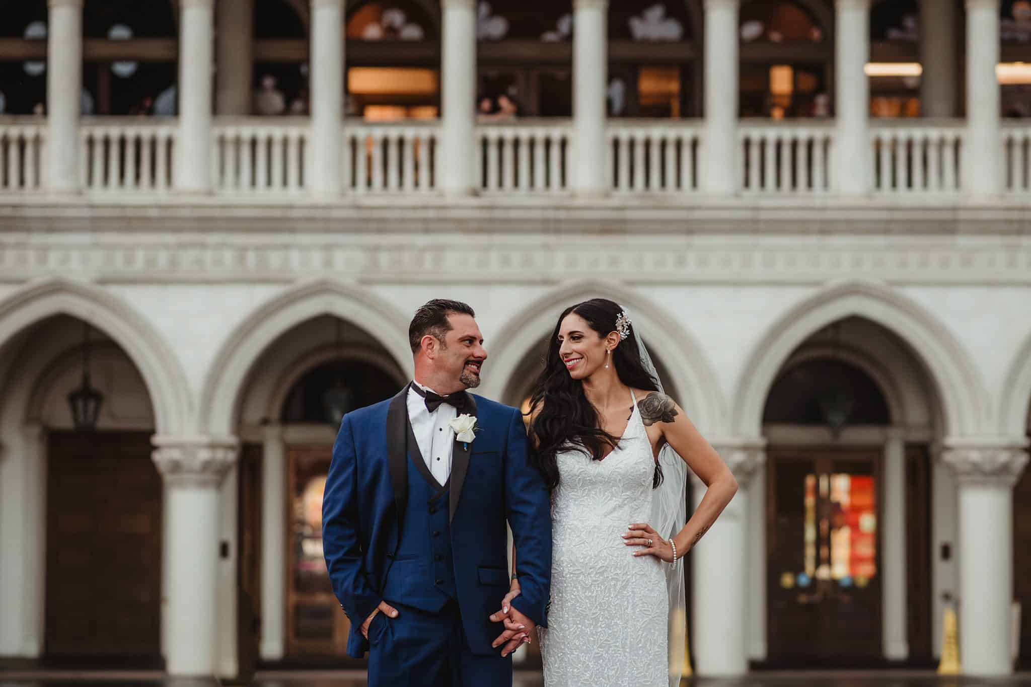 Couple standing outside of the Venetian in the rain | Rainy Las Vegas Venetian Elopement | Amber Garrett Photography | Adventure Wed Feature